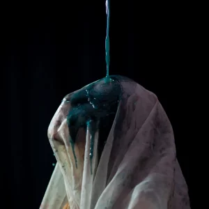 Ein verhüllter Kopf wird von blauer Flüssigkeit übergossen – ein kraftvolles Bild für Identitätsauflösung, kreative Transformation und experimentelles Storytelling im Design.