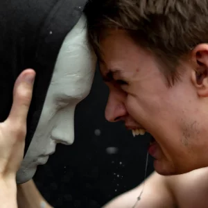 Eine intensive Szene: Ein junger Mann schreit eine maskenhafte Figur an – ein Bild für kreative Konzepte mit emotionaler Wirkung und starkem visuellen Storytelling